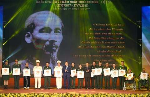 Prime Minister Nguyen Xuan Phuc presents gifts for revolutionary contributors at the event (Source: VGP)