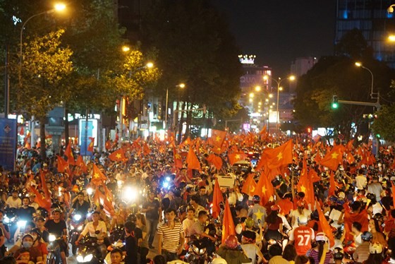 Football fans with national flags, trumpets and drums flock to streets cheering the victory