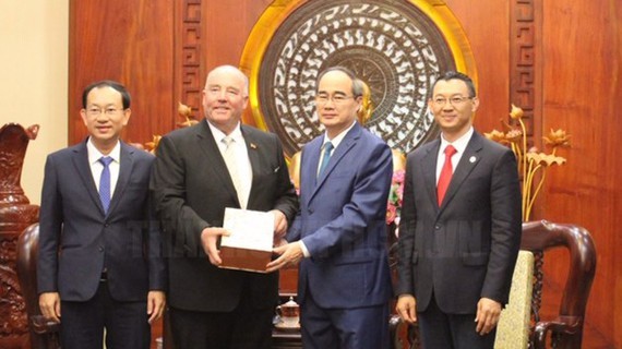 Secretary of the Party Committee of Ho Chi Minh City Nguyen Thien Nhan offers a souvenir to  former Ambassador of Germany to Vietnam Rolf Schulze