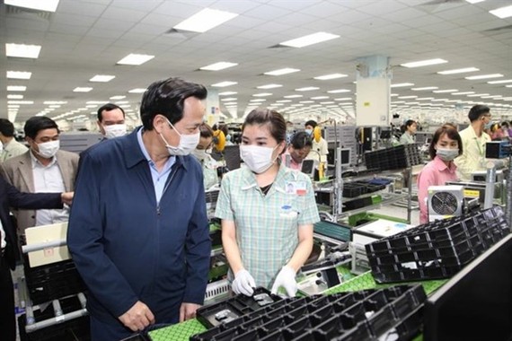 Minister of Labour, Invalids and Social Affairs Dao Ngoc Dung (L) visits Samsung Electronics Vietnam in Thai Nguyen province on February 13 (Photo: vtc.vn)