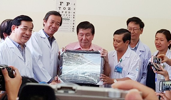 Bác sĩ Nguyễn Văn Vĩnh Châu, Giám đốc Bệnh viện Bệnh Nhiệt đới tặng bệnh nhân H. bức hình lưu niệm