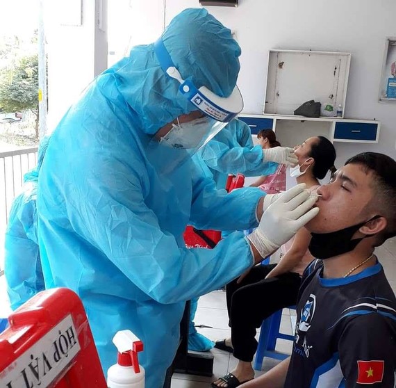 Nhân viên y tế lấy mẫu xét nghiệm cho công nhân tại Khu chế xuất Tân Thuận (quận 7)