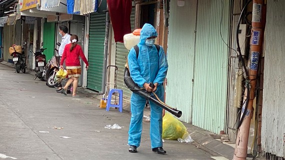 Khử khuẩn bên hông chợ Phú Nhuận. Ảnh: CAO THĂNG