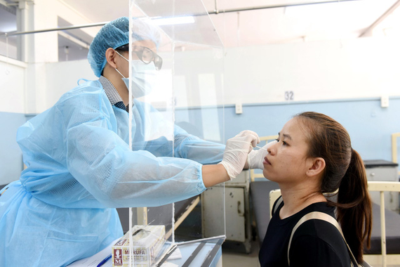 Nhân viên y tế lấy mẫu xét nghiệm cho người dân tại Bệnh viện Nhân dân Gia Định 