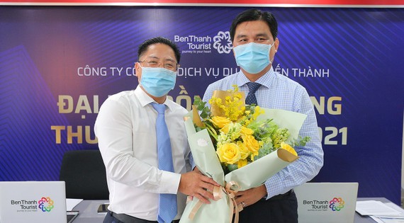 Ông Vũ Đình Quân, nguyên Chủ tịch HĐQT BenThanh Tourist (bên trái) tặng hoa chúc mừng ông Hoàng Tâm Hòa, tân Chủ tịch HĐQT BenThanh Tourist