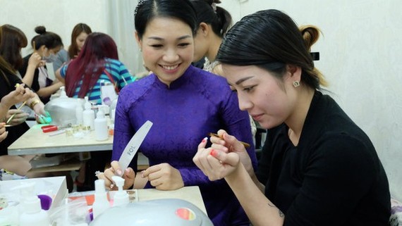 華人美甲師龐美玲（左）正在教學員美甲技藝。