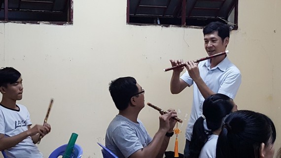 甘偉恒老師在教學生吹簫。