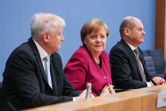 3月12日，在德國首都柏林，德國總理、基民盟主席默克爾（中），社民黨代主席肖爾茨（右）和基社盟主席澤霍費爾出席新聞發佈會。（圖源：新華網）