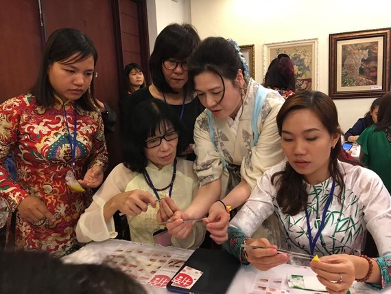 來自日本小布花布料協會的會員親自指引婦女手製日式布花。