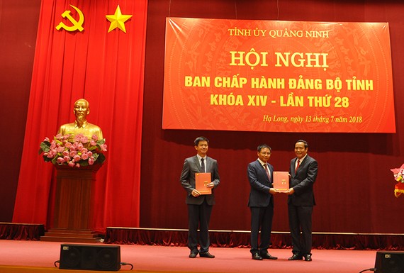 中央組織部常務副部長阮清平向黎光松、阮文勝兩位同志頒發黨中央政治局的幹部輪換部署《決定》。
