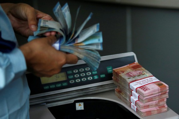由於印尼盾汇率已逼近1美元兑15000印尼盾，处于20年来的低位，导致雅加达股市受压猛跌。图为雅加达一家货币兑换商前天數點的印尼盾钞票。（圖源：路透社）