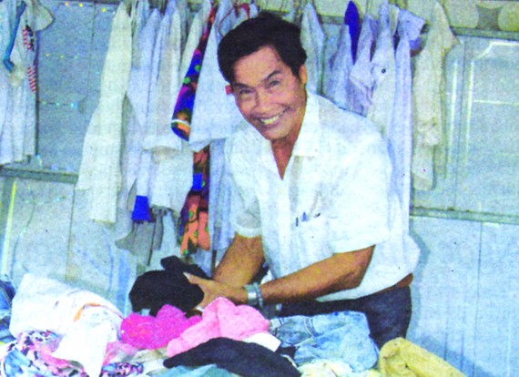 阮先生在自己的免費舊衣服攤內。