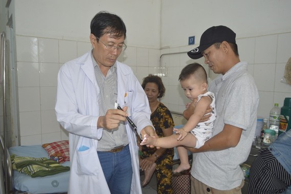 同塔省全科醫院兒童科長黃鴻福醫生在為一名病童看診。（圖源：陳玉）