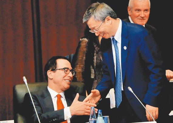 在日本福岡召開的G20財長和央行行長會議上，大陸人民銀行行長易綱（右）與美國財政部長穆努欽（左）握手。（圖源：路透社）