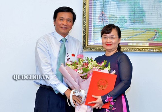 國會秘書長、國會辦公廳主任阮幸福（左）向范翠征同志（右）頒發國會常務委員會第705號《決議》並贈送鮮花祝賀。（圖源：Quochoi.vn）