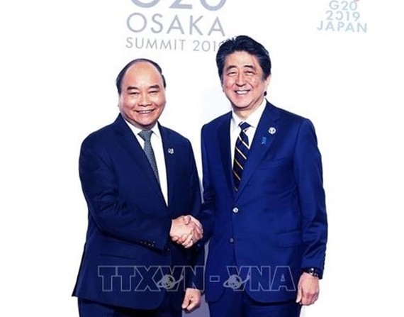 政府總理阮春福（左）與日本首相安倍晉三握手。（圖源：越通社）