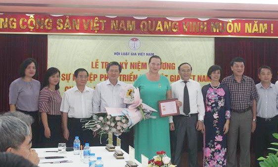 俄羅斯“和平之路”國際基金主席烏姆諾瓦‧伊琳娜‧安納托利耶夫納教授（中）榮獲“為越南法學家協會發展事業”紀念章。（圖源：P.Mai）