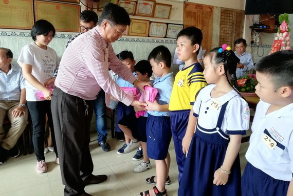 鄧氏宗祠理事長鄧栢榮向小學生們頒獎。