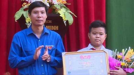 拾遺不昧的七年級A班學生阮平明（右）獲頒發該省共青團執委會的獎狀。（圖源：越通社）