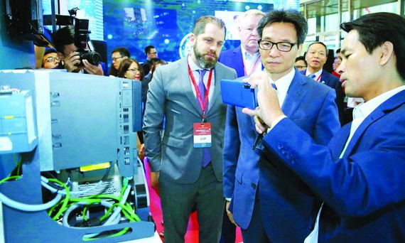 政府副總理武德膽（右二）參觀越南的資訊技術產品。（圖源：越通社）
