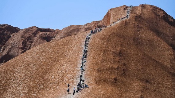 攀登“烏魯魯”巨岩的遊客排成了長隊。（圖源：互聯網）
