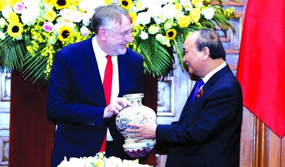 政府總理阮春福（右）向博納德主席贈送紀念品。（圖源：越通社）