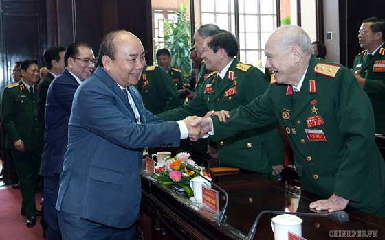 政府總理阮春福（前左）與退伍軍人交談。（圖源：Chinhphu.vn）