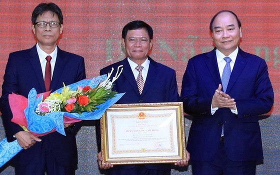 政府總理阮春福（右）向第三區域政治學院頒授一等勞動勳章。（圖源：越通社）