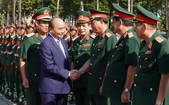 阮春福總理（前左）同第五軍區司令部幹部親切握手，互致問候。（圖源：光孝）