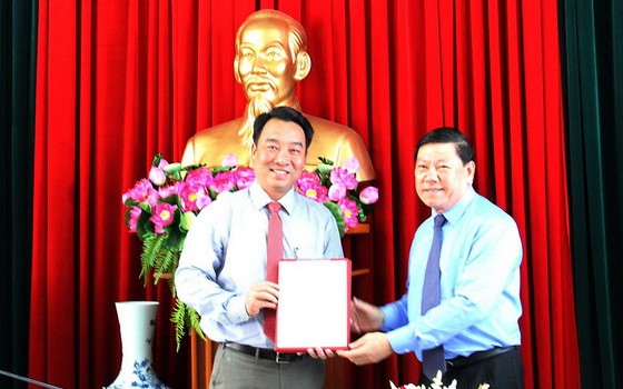 新任永隆省人委會主席呂光亮（左）接領人事委任《決定》。（圖源：VNN）