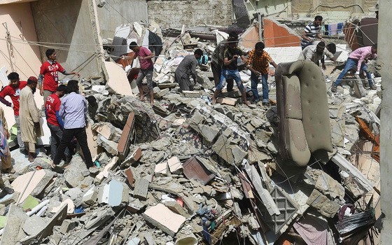 救援人員在居民樓倒塌事故現場救援。（圖源：AFP）