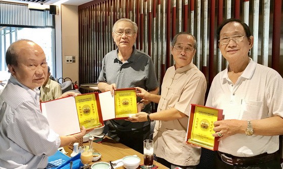 黃有義理事長（右二）向各書畫家贈送紀念章。