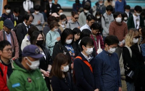 東京市民戴著口罩悼念“三‧一一”大地震逝者。（圖源：路透社）