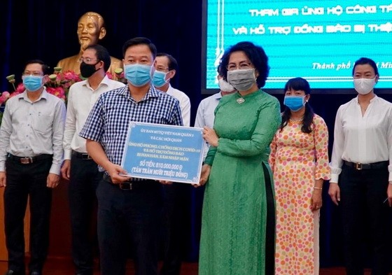市越南祖國陣線委員會主席蘇氏碧珠接受第五郡領導的抗疫善款。