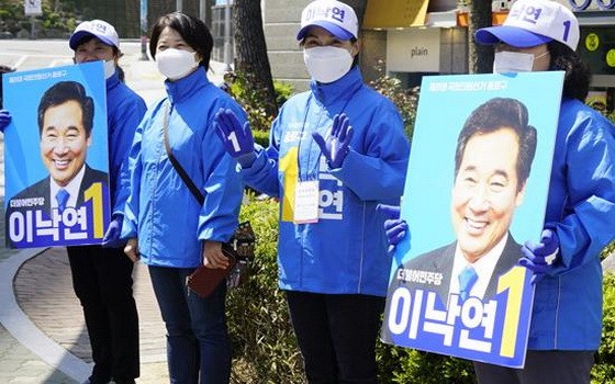 4月14日，首爾民眾在街頭手舉支持者海報號召投票。 （圖源：互聯網）