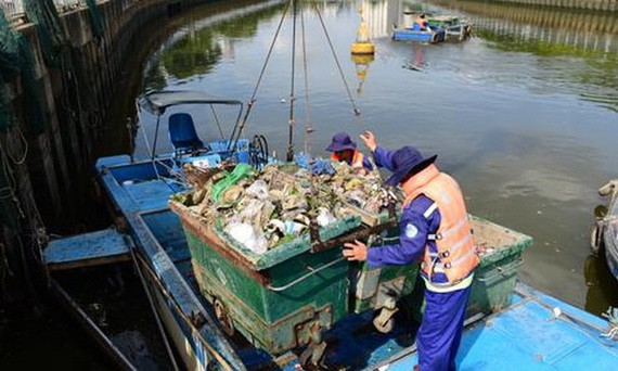 清潔員在饒祿-氏藝涌上打撈垃圾，確保湧渠暢通美觀。（圖源：田升）