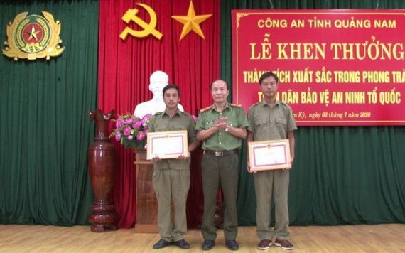 廣南省公安廳代表（中）向 2名取得出色成績的民兵隊員頒授獎狀。（圖源：明俊）