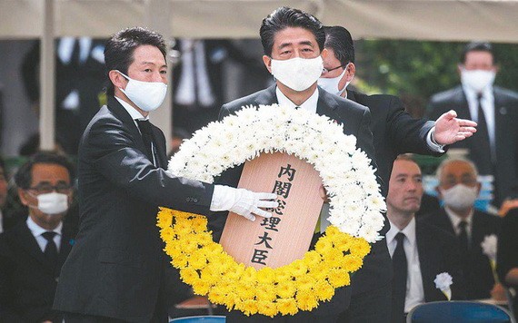 日本首相安倍晉三（中）9日在長崎市原爆75周年紀念儀式獻上花圈。（圖源：AFP）