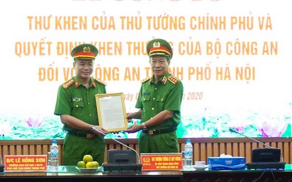 公安部副部長黎貴王（右）向河內市公安廳頒授政府總理簽發的表彰信及獎狀。（圖源：首都安寧報）