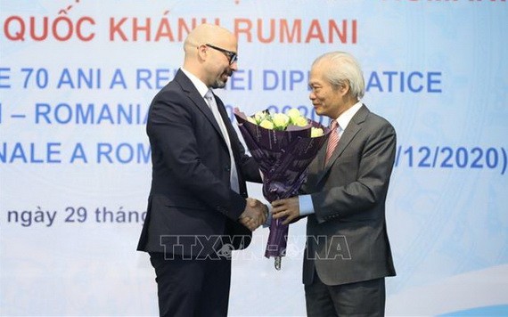 越南-羅馬尼亞友好協會主席宋文俄（右）向羅馬尼亞駐越大使館領事拉杜送鮮花慶祝羅馬尼亞國慶。（圖源：越通社）