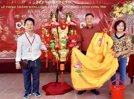 理事長鄒國榮(左)向陸國明夫婦轉交投得的《觀音蓮花寶燈》。