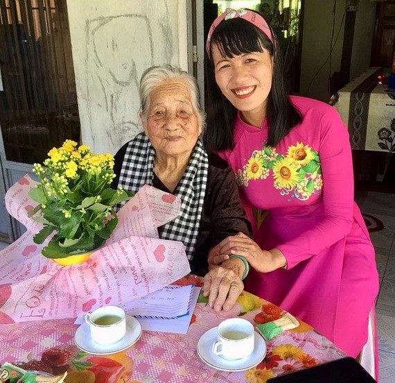 阮氏明心帶著學生的鮮花和信探望越南英雄母親陳氏近。