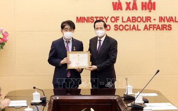 ILO駐越南首席代表李昌徽博士（左）榮獲“為勞動與榮軍社會事業”紀念章。（圖源：越通社）
