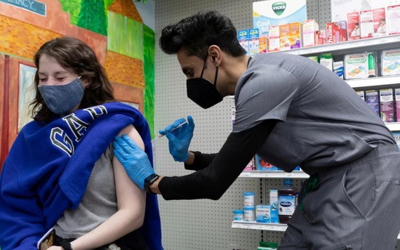 一名女性在美國賓夕法尼亞州當地一家藥房接種輝瑞新冠疫苗。（圖源：路透社）