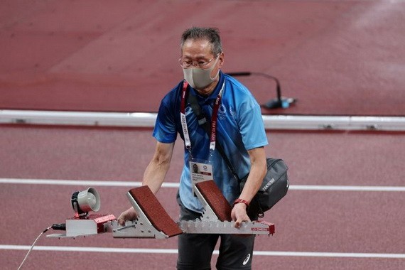 圖為一名日本高齡志工在東京奧運會期間幫助設置起跑架。（圖源：互聯網）