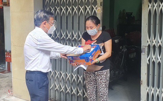 市委民運處主任阮友協向華人貧窮邊緣戶贈送援助品。