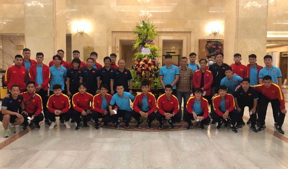 越南男子足球隊在國家主席贈送的花籃旁合影留念。（圖源：VFF）