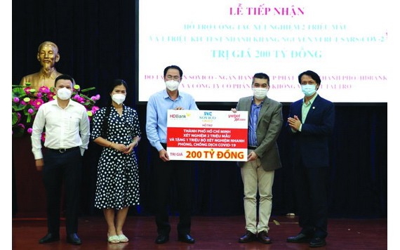 市越南祖國陣線委員會常務副主席阮成忠(左三)接收捐款與頒贈感謝狀。