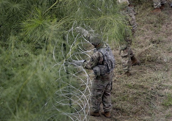 美國士兵在美墨邊境安裝鐵絲網嚴防移民入境。（圖：互聯網）