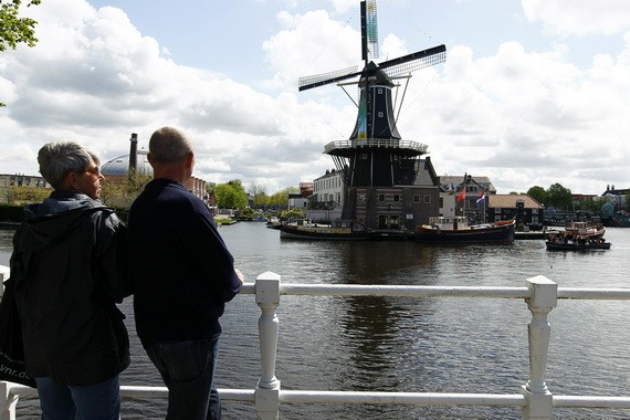 圖為遊客在荷蘭哈勒姆欣賞一座建於1779年的風車。（圖源：新華社）